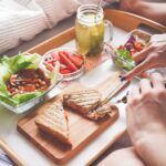 Young Woman Enjoying Morning Breakfast in Bed
