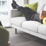 Young Man Napping on White Sofa in the Office